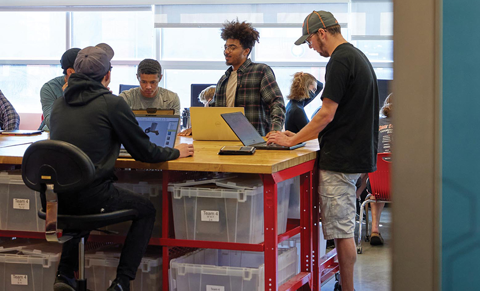 一群学生在工程空间使用笔记本电脑