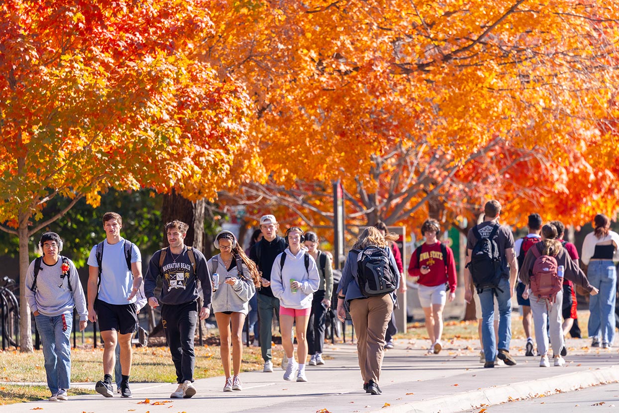 Sidewalk full of walking students on a fall day.