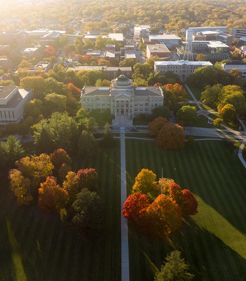 Drone view of central campus as the sun sets on a fall evening.