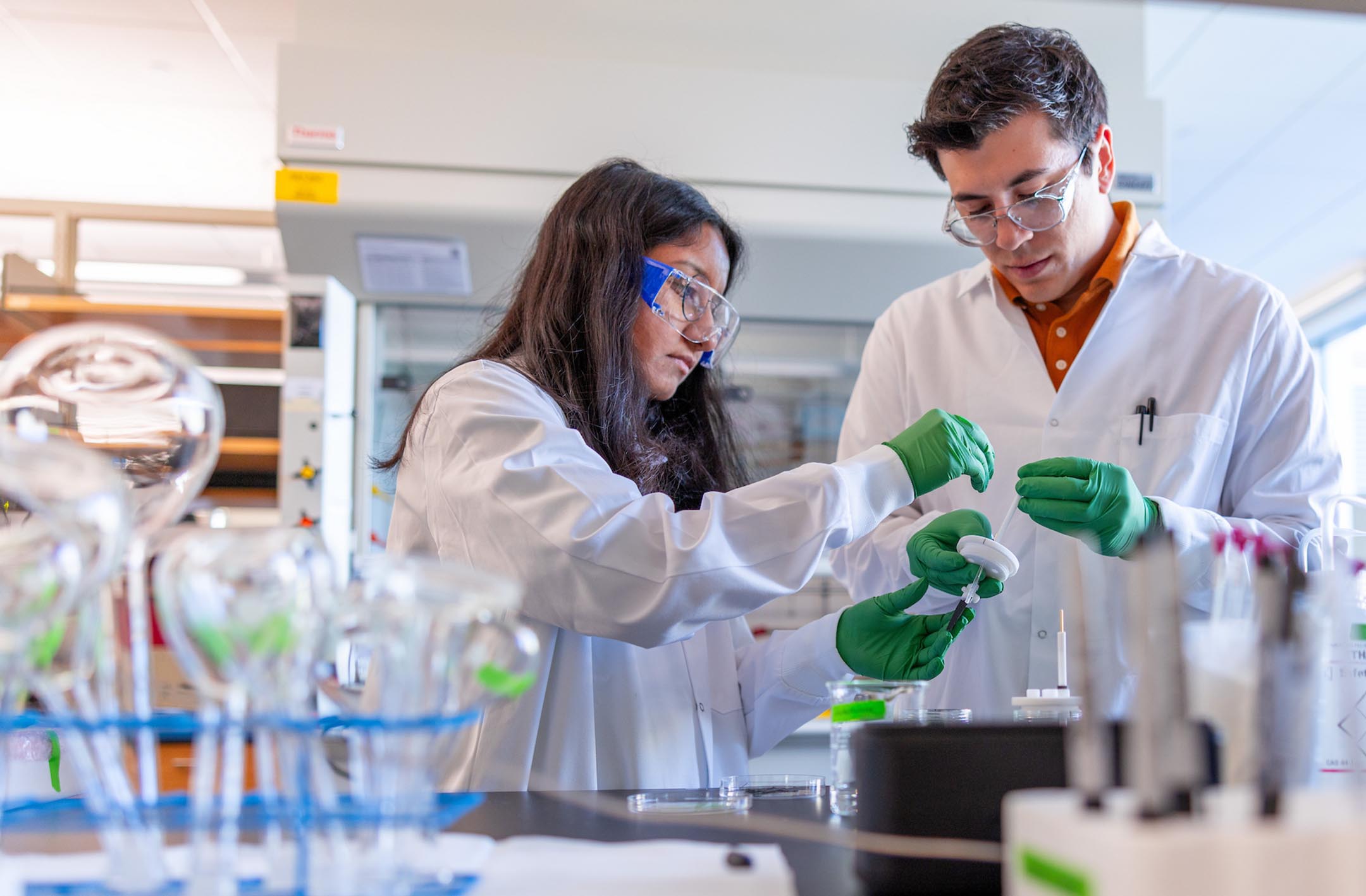 Two students using equipment in a laboratory.