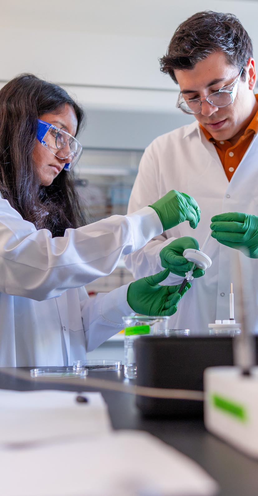 Two students using equipment in a laboratory.