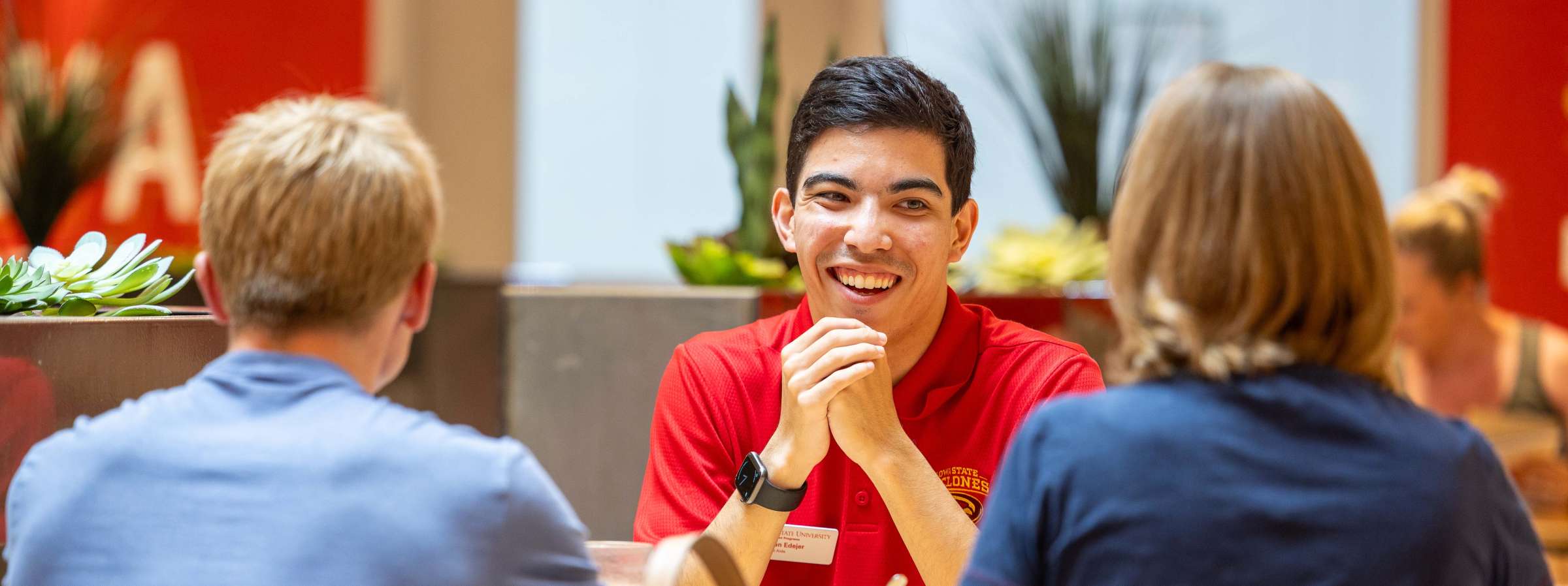 A Cyclone Aide meets with a family during orientation dinner.