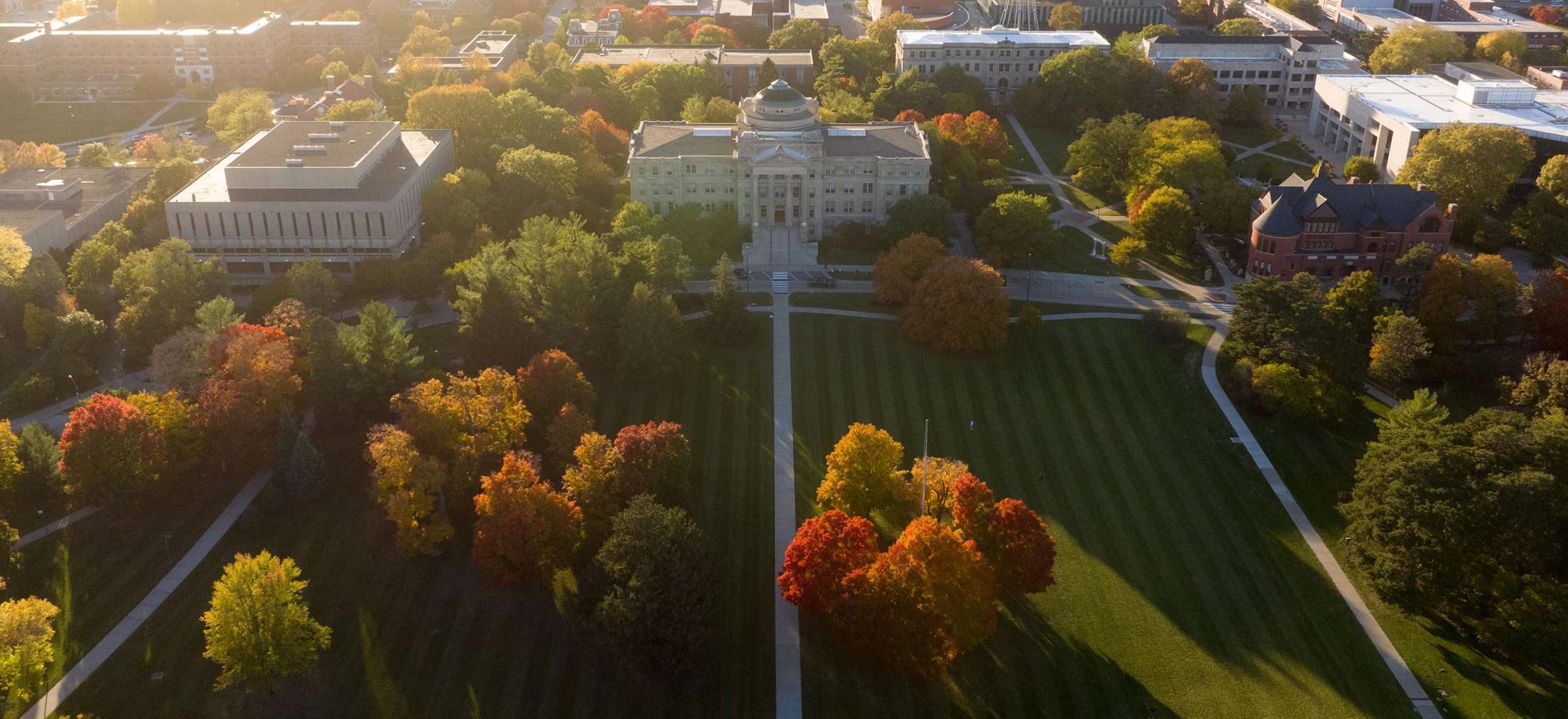 Drone view of central campus as the sun sets on a fall evening.